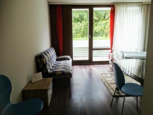 汉诺威Hannover Messe Wohnung 2的带沙发和椅子的客厅以及窗户。
