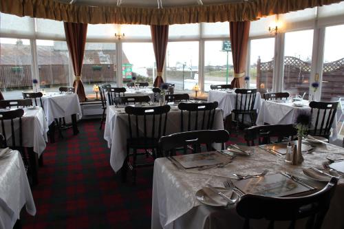 伦丁林克斯阿普拉格餐厅酒店的用餐室配有桌椅和白色的桌布