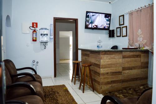 里奥韦尔迪Hostel Prime的厨房设有酒吧,墙上配有电视。