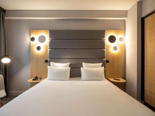 布鲁塞尔诺富特布鲁塞尔迷笛中心酒店的卧室配有一张带两个枕头的大白色床