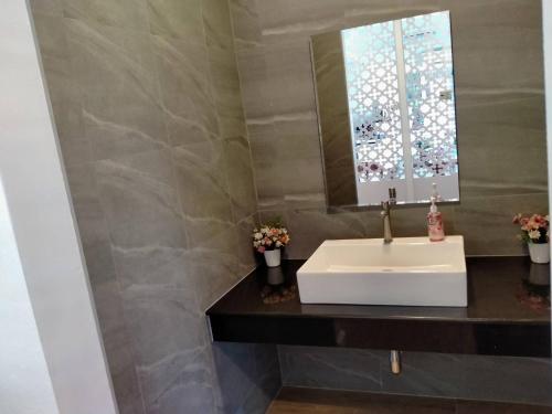 清莱Feelathome的浴室设有白色水槽和镜子