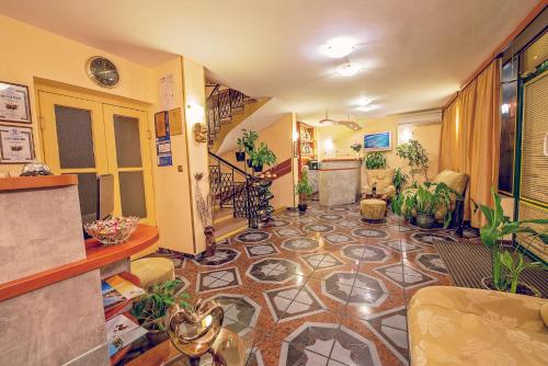 瓦尔纳彩色酒店的走廊上设有瓷砖地板,里面种植了植物