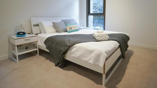 悉尼SYDNEY CBD WALK TO DARLING HARBOUR MODERN 1 BED APT NSY188的卧室配有两张床、床头柜和一张西德西德西德床