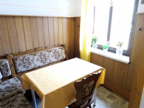 GeyerFerienwohnung Erzgebirge的一间设有桌子、长凳和窗户的房间