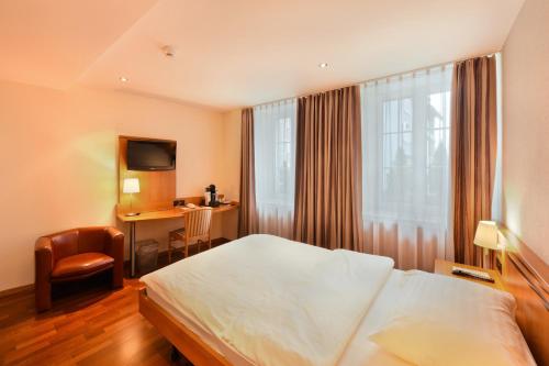 措芬根Apart Hotel Amadeo的配有一张床和一张书桌的酒店客房