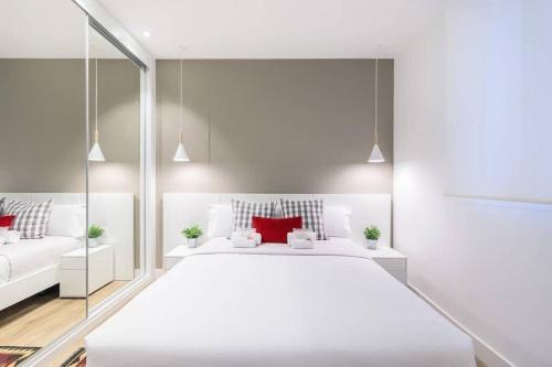 圣塞瓦斯蒂安BUENPAS的白色卧室配有一张带红色枕头的大白色床