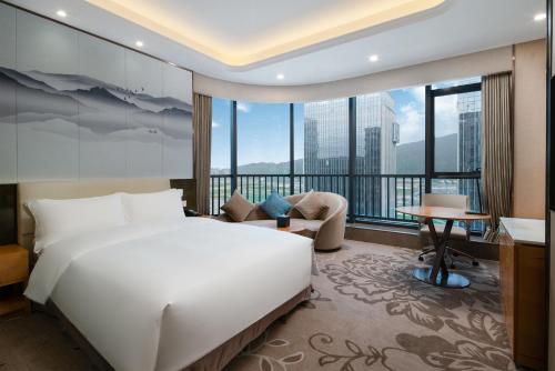 珠海珠海横琴乾元酒店的卧室设有一张白色大床和大窗户
