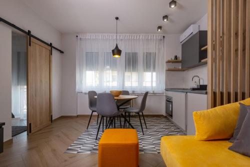 诺维萨德Republic Square Apartment - with garage的厨房以及带桌椅的起居室。