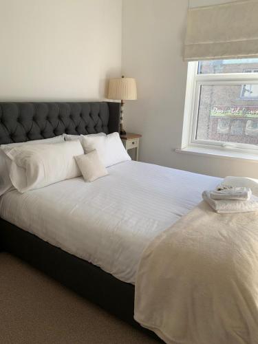 杜伦Durham Serviced Properties - The Sanctuary的卧室配有一张大白色床和窗户