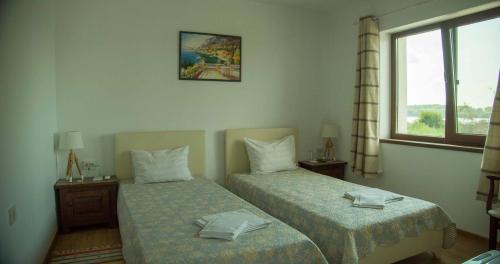 TutrakanКъща за гости Лодката的酒店客房设有两张床和窗户。