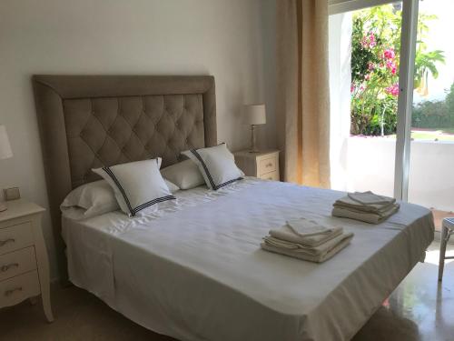 EsteponaApartment Costalita, direct beach access, ground floor, salt water pool的一间卧室配有一张大床和毛巾