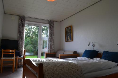 斯凯拜克Motel Sydvest的一间卧室设有一张床和一个大窗户