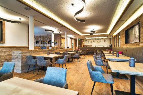 博登迈斯Resort Hotel的餐厅设有木桌和蓝色椅子