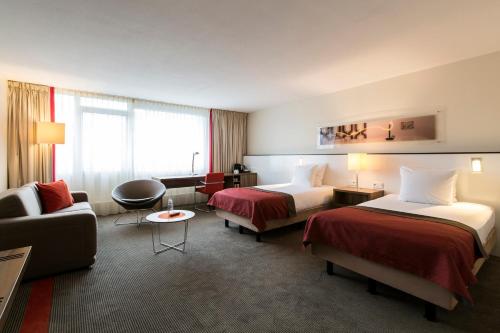 埃因霍温Holiday Inn Eindhoven Centre, an IHG Hotel的酒店客房,设有两张床和一张沙发