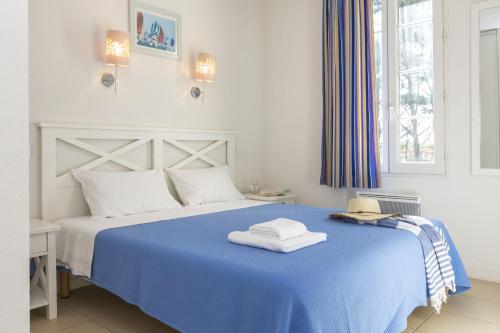 奥雷龙圣皮耶尔Résidence Odalys Terre Marine的一间卧室配有蓝色的床和毛巾