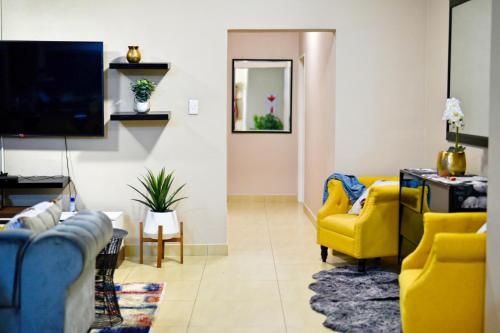 埃祖尔韦尼Valleyside Executive Apartments的客厅配有黄色椅子和电视