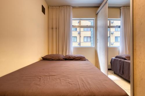库里提巴Ótimo apartamento no Centro mobiliado e com garagem的一个小房间的一个床位,设有窗户