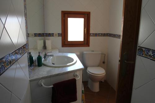 莱图尔Casa Rural Manuel y Dolores的一间带水槽和卫生间的浴室以及窗户。