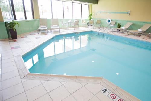 费尔伯恩Holiday Inn Dayton/Fairborn I-675, an IHG Hotel的大楼内带桌椅的大型游泳池