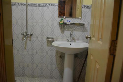 拉合尔Rose Palace Hotel, Liberty的浴室设有白色水槽和镜子