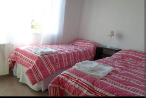 埃尔卡拉法特DEPARTAMENTO CALAFATE CENTRICO的配有红色和白色毯子的客房内的两张床