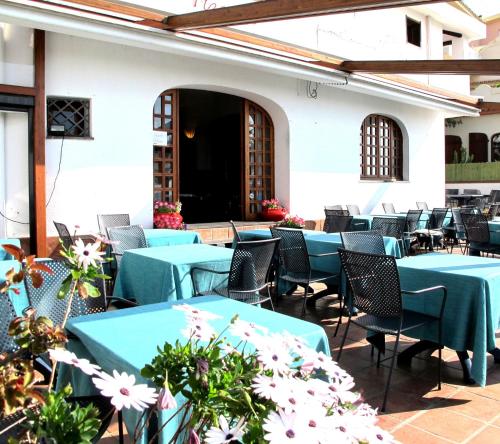 卡拉古诺内波普酒店的庭院设有蓝色的桌椅和鲜花