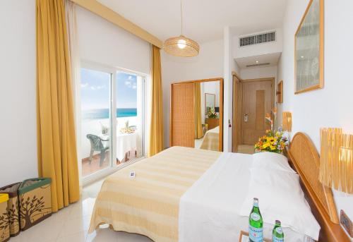 加利波利Ecoresort Le Sirene - Caroli Hotels的一间卧室设有一张床,享有海景