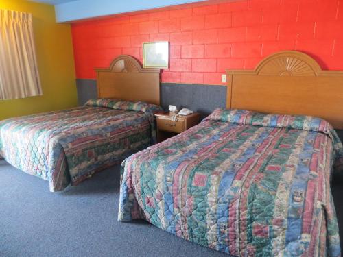 Adair阿达尔经济汽车旅馆的酒店客房设有两张床和红色的墙壁。