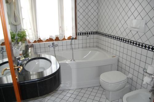 圣文森特奥林匹克酒店的带浴缸、卫生间和盥洗盆的浴室