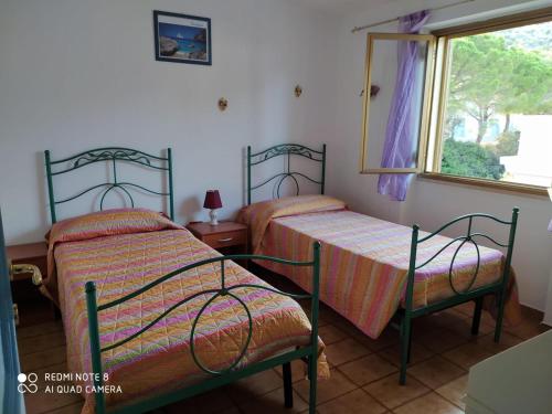 卡拉古诺内Appartamenti Manuela的带窗户的客房内设有两张单人床。