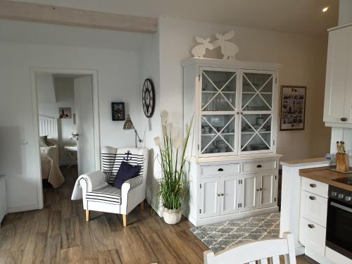 朱列斯拉赫Ferienwohnung Muschelsucher的厨房配有白色橱柜和桌椅