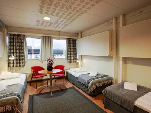 万塔迪古里拉酒店的酒店客房带两张床和一张桌子以及椅子。