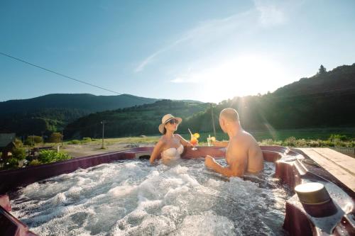 米日吉里亚SPA Hotel Zhyva Voda的坐在热水浴缸中的男人和女人