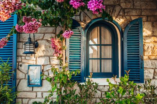 王子岛群Büyükada Loc'ada的石头建筑中带蓝色百叶窗的窗户,花朵