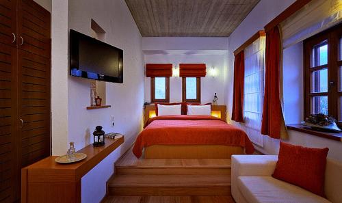 沃武萨克拉斯酒店的一间卧室配有红色的床和一张沙发