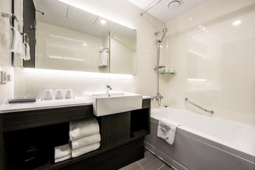 首尔首尔黄金酒店的浴室配有盥洗盆、浴缸和盥洗盆