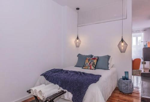 里斯本Luxury Beato Trendy Location的一间卧室配有一张带蓝色枕头和灯光的床。
