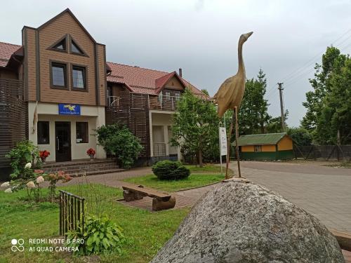 BerżoryAuksinė gervė的鸟在房子前的岩石上的雕像