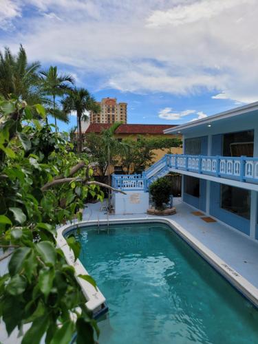 劳德代尔堡Hotel Motel Lauderdale Inn的一座游泳池,其建筑背景为: