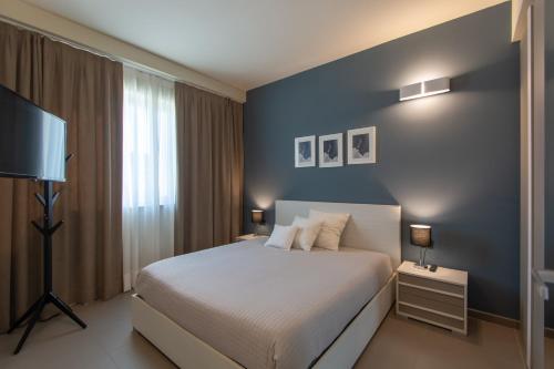 博尔加罗托里内塞ATMOSFERA APARTMENTS & SUITES的一间卧室设有一张床和蓝色的墙壁