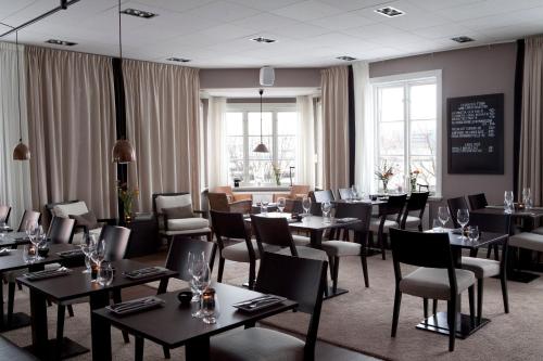 哥德堡Hotel Villan的餐厅设有桌椅和窗户。