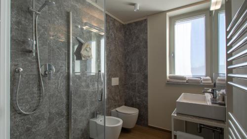 博尔加罗托里内塞ATMOSFERA APARTMENTS & SUITES的带淋浴、卫生间和盥洗盆的浴室