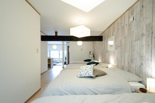 函馆Hakodateyado Mizuki - Vacation STAY 97486的一间卧室设有两张床和木墙