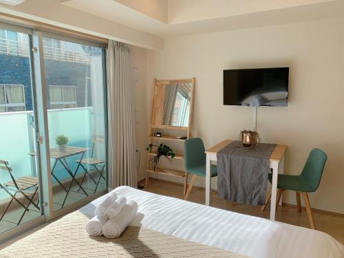 东京intheHood Tsukiji - Vacation STAY 97734的一间卧室配有一张床、一张桌子和一台电视