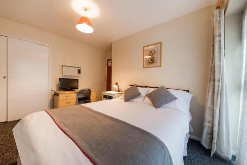 阿克斯桥OYO Honeycroft Lodge的卧室配有一张白色大床和电视。