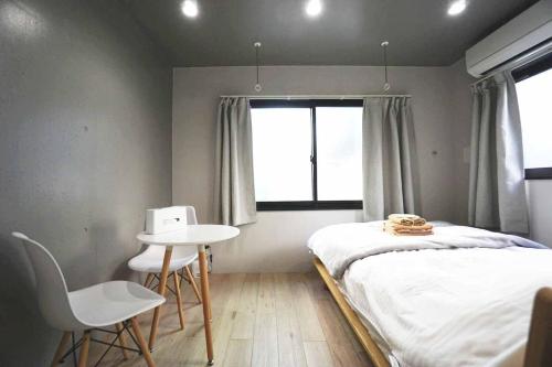 东京Ebisu Ebisu - Vacation STAY 98468的一间卧室配有一张床、一张桌子和一个窗户。