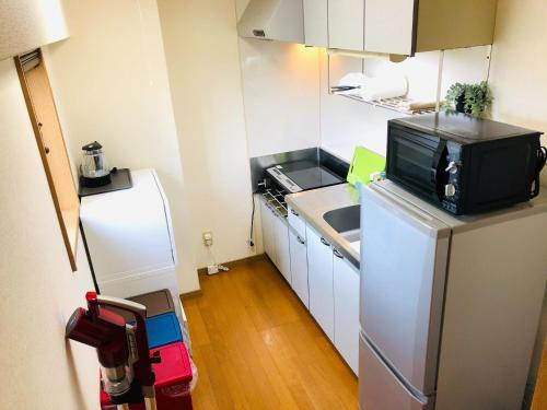熊本YK Mansion Sannomaru - Vacation STAY 98241的小厨房配有冰箱和微波炉。