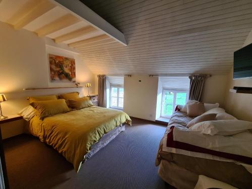 布兰维尔苏米尔lesroses1680的一间卧室设有两张床和窗户。
