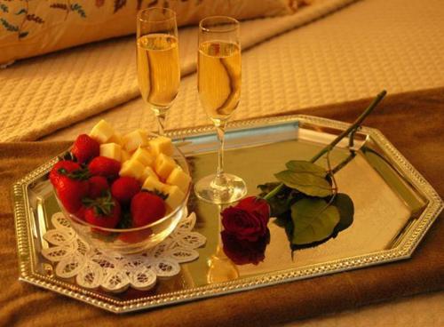 萨凡纳雷诺广场普兰特斯酒店的托盘,包括一碗水果和两杯香槟酒杯