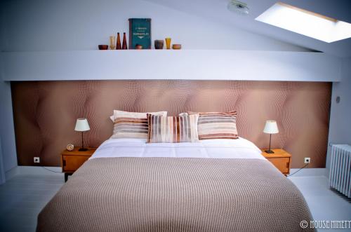 布鲁塞尔九十家住宿加早餐旅馆的一间卧室配有一张大床和两盏灯